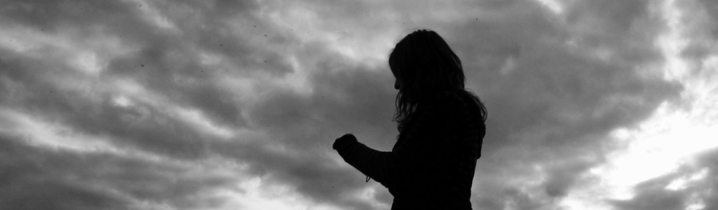 Silhouette of woman amid storm clouds